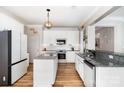 Bright kitchen featuring white cabinetry, stainless steel appliances, granite countertops, and wood-look flooring at 4001 Brook Valley Run, Monroe, NC 28110