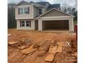Two-story home featuring an attached two-car garage and red shutters, set against a natural backdrop at 438 Phifer Rd, Kings Mountain, NC 28086