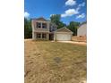 Charming two-story home with a light beige exterior, brick-red shutters and a two-car garage at 438 Phifer Rd, Kings Mountain, NC 28086
