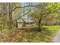 Quaint home with a welcoming front porch nestled within a lush, wooded landscape with a green lawn at 4896 Birch Cir, Hickory, NC 28602