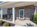 Cozy front porch featuring stone details, a seating area, and decorative plants at 504 Cranford Dr, Pineville, NC 28134