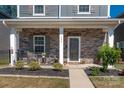 Inviting front porch with stone accents, seating area, and well-maintained landscaping at 504 Cranford Dr, Pineville, NC 28134