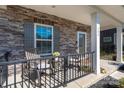 Close up of a front porch with stone accents, seating, and decorative welcome mat at 504 Cranford Dr, Pineville, NC 28134