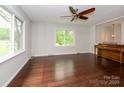 Sunlit living room featuring rich hardwood floors and an elegant piano at 5601 Indian Brook Dr, Matthews, NC 28104