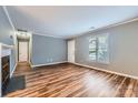 Spacious living room features hardwood floors, a fireplace, and ample natural light through a large window at 5913 Crape Myrtle Ln, Charlotte, NC 28216