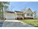 Well-maintained home featuring an attached garage, manicured lawn, and a welcoming front porch at 623 Roxboro Dr, Mount Gilead, NC 27306
