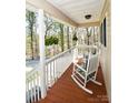 Inviting front porch with rocking chairs and hanging plants creating a relaxing space at 623 Roxboro Dr, Mount Gilead, NC 27306
