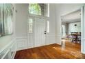 Bright foyer with hardwood floors, wainscoting, and arched transom window above the front door at 6519 Summertree Ln, Charlotte, NC 28270