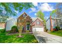 Beautiful two-story brick home with well-maintained lawn, attached garage, and mature trees at 6519 Summertree Ln, Charlotte, NC 28270