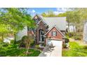 Two-story brick home with a manicured lawn, attached garage, and mature trees under a blue sky at 6519 Summertree Ln, Charlotte, NC 28270