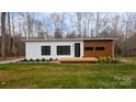 A modern single-story home with minimalist design, wood accents, and well-manicured landscaping at 6548 Emerald Isle Dr, Sherrills Ford, NC 28673