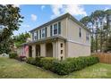Two-story home featuring brick and siding, green shutters, a well-manicured lawn, and a charming covered front porch at 6807 Stoney Ridge Rd, Matthews, NC 28104