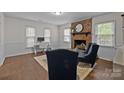 Inviting living room featuring a brick fireplace, hardwood floors, and neutral decor creating a warm atmosphere at 6807 Stoney Ridge Rd, Matthews, NC 28104