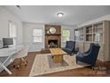 Cozy living room with brick fireplace, wood floors, and large windows providing natural light at 6807 Stoney Ridge Rd, Matthews, NC 28104