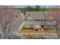Aerial view of a brick townhome showcasing its location in a neighborhood with mature trees and landscaping at 9001 Lanark Ln, Indian Land, SC 29707