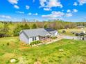 Aerial view of a charming single story home and metal outbuilding nestled on a sprawling green lot at 909 Old Mocksville Rd, Statesville, NC 28625
