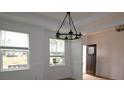 Inviting dining room with elegant chandelier, wainscoting, natural light, and view to door at 919 Mankey Dr, Huntersville, NC 28078