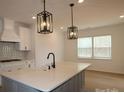 Modern kitchen showcasing a large island with sink and pendant lights, sleek countertops, and stainless steel appliances at 919 Mankey Dr, Huntersville, NC 28078