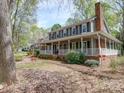 Inviting home with a large front porch, brick accents, and mature trees at 940 Brittany Ct # 23, Gastonia, NC 28056
