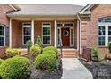 Inviting front porch featuring a brick facade, decorative columns, and a stylish front door at 9506 Minnie Lemmond Ln # 170, Mint Hill, NC 28227