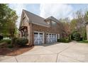 Spacious three-car garage with ample driveway space, side entry door, and mature landscaping at 11308 Wheat Ridge Rd, Charlotte, NC 28277