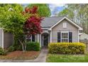 Charming home exterior featuring a well-maintained lawn, mature landscaping, and inviting front entryway at 12804 Lismorre Castle Ct, Charlotte, NC 28273
