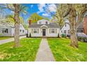 Charming home featuring a landscaped front yard, mature trees, and a inviting walkway to the front door at 1409 Effingham Rd, Charlotte, NC 28208