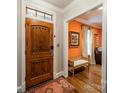 Inviting foyer features a wooden front door and leads to a living space with warm, orange walls at 1529 S Wendover Rd, Charlotte, NC 28211