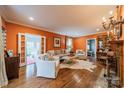 Spacious living room with warm-colored walls, hardwood floors, fireplace, and ample seating at 1529 S Wendover Rd, Charlotte, NC 28211