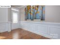 Elegant entryway featuring wainscoting, hardwood floors, and stylish wall art at 158 Ventor Way, Mooresville, NC 28115