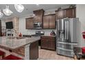 Modern kitchen with granite countertops, stainless steel appliances, and dark wood cabinets offering ample storage at 16038 Red Buckeye Ln, Huntersville, NC 28078