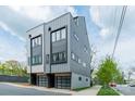 Contemporary townhome featuring a gray exterior, glass-paneled garage doors, and well-maintained curb appeal at 1933 W Trade St, Charlotte, NC 28216