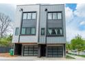 Stylish townhome displaying modern design with gray siding, sleek garage doors, and well-lit entrances at 1933 W Trade St, Charlotte, NC 28216