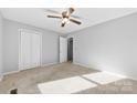 Neutral bedroom featuring plush carpet, ceiling fan and ample closet space at 2124 Marquesas Ave, Tega Cay, SC 29708