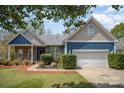 Charming home featuring stone accents, blue siding, a well-manicured lawn and an attached two-car garage at 3846 Bent Creek Sw Dr # 58, Concord, NC 28027