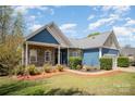 Charming single-story home with blue accents, stone, manicured lawn and an attached two-car garage at 3846 Bent Creek Sw Dr # 58, Concord, NC 28027