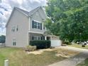 Charming two-story home features a brick and gray exterior, well-manicured landscaping, and a two-car garage at 6008 Grassy Knoll Cir, Matthews, NC 28104