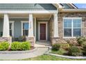 Inviting front porch with stone pillars, cozy seating, and a glimpse of the home's exterior design at 7130 Irongate Dr, Indian Land, SC 29707