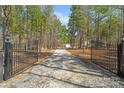 Long gravel driveway through a gated entrance leading to a private estate surrounded by trees at 722 Clegg Farm Dr, York, SC 29745