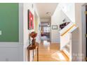 Bright hallway with hardwood floors, staircase, and elegant decor, offering a warm welcome at 7554 Coastal Way, Huntersville, NC 28078