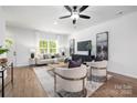 Inviting living room featuring hardwood floors, neutral furniture, and large windows, creating a bright and airy atmosphere at 8007 Willhill Rd, Mint Hill, NC 28227