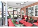 Inviting screened-in patio with red cushions, brick detail, and outdoor decor, perfect for relaxing or entertaining guests at 8518 Christalina Ln, Denver, NC 28037