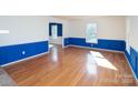 Bright living room with hardwood floors, decorative wall trim, and ample natural light at 916 Rollingwood Dr, Mount Holly, NC 28120