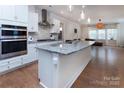Open concept kitchen with stainless steel appliances, granite countertops, and hardwood floors at 938 Moose Trl, Matthews, NC 28104