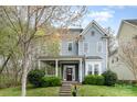 Charming two-story home features a welcoming porch, a well-manicured lawn, and beautiful landscaping at 9832 Sunriver Rd, Huntersville, NC 28078