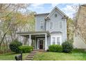 Charming two-story home features a welcoming porch, a well-manicured lawn, and beautiful landscaping at 9832 Sunriver Rd, Huntersville, NC 28078