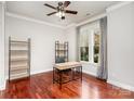 Bright office with hardwood floors, shelving, a modern desk, and a large window at 9832 Sunriver Rd, Huntersville, NC 28078