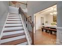 Bright foyer featuring hardwood floors, a staircase with iron railings, and an open view to the dining room at 10728 Bere Island Dr, Charlotte, NC 28278