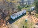Aerial view of a cozy single-story home surrounded by mature trees at 1076 Percy Ln, Rockwell, NC 28138