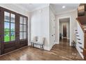 Bright foyer features hardwood floors, a double front door with glass panes and white trim at 109 Redbird Ln, Weddington, NC 28104